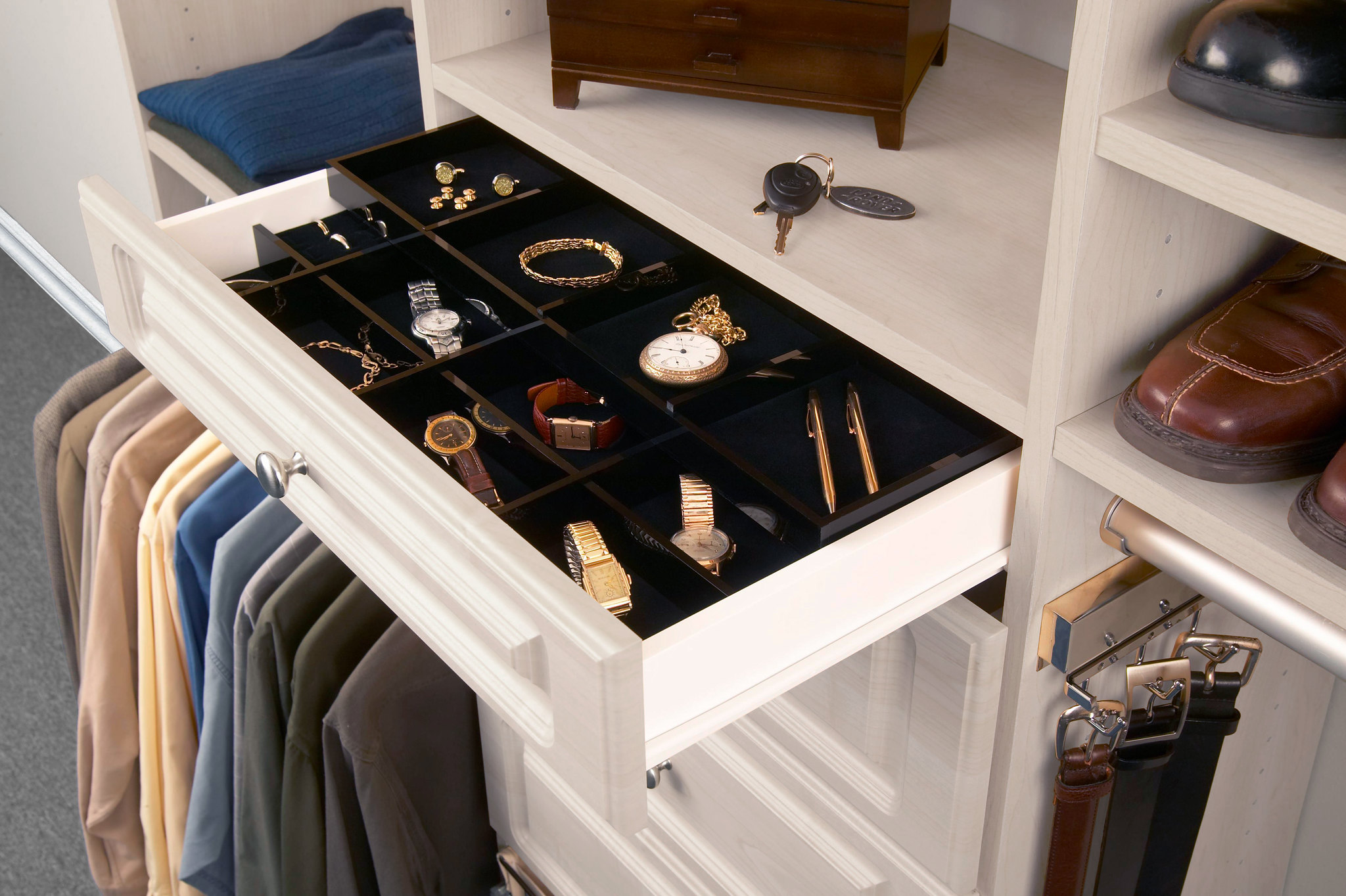 An open custom closet drawer with a black velvet-lined compartmentalized organizer tray, perfectly organizing men's luxury watches, cufflinks, and pens.