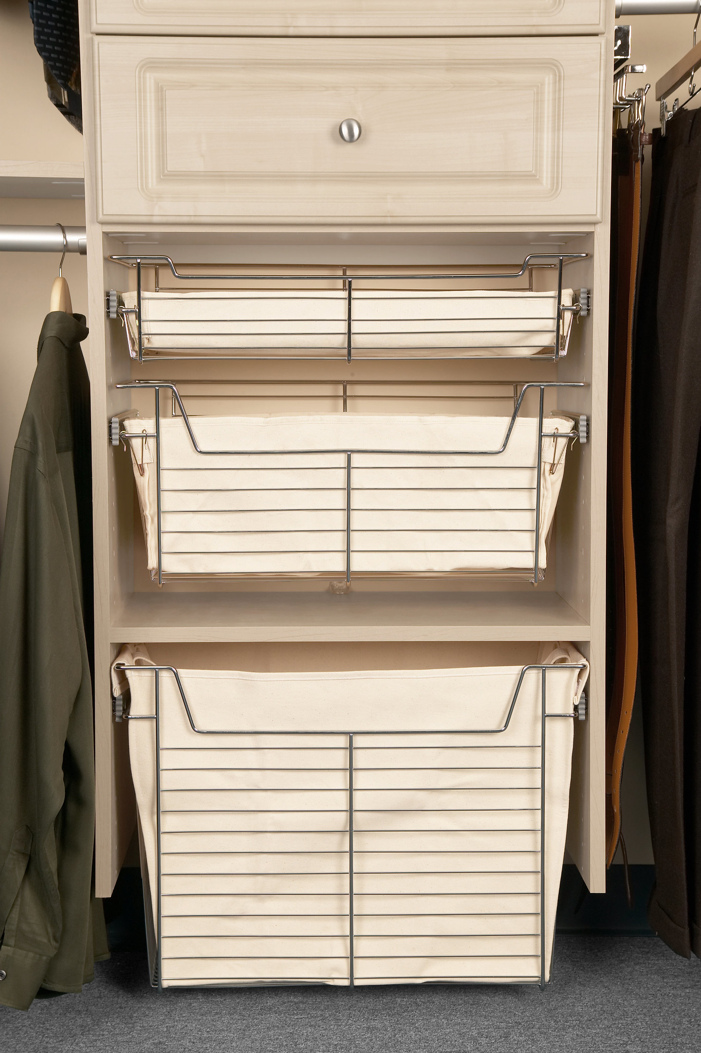 This custom white closet storage unit features three stacked wire basket drawers with canvas liners, perfect for elegant laundry or general organization.